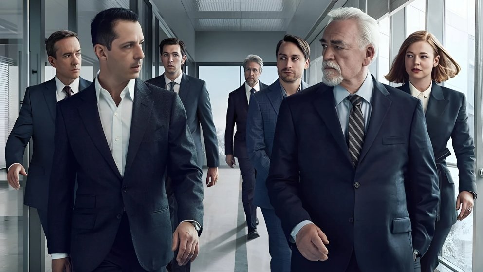 The main cast of Succession in a corporate hallway, with Logan Roy leading while his children and executives follow behind.