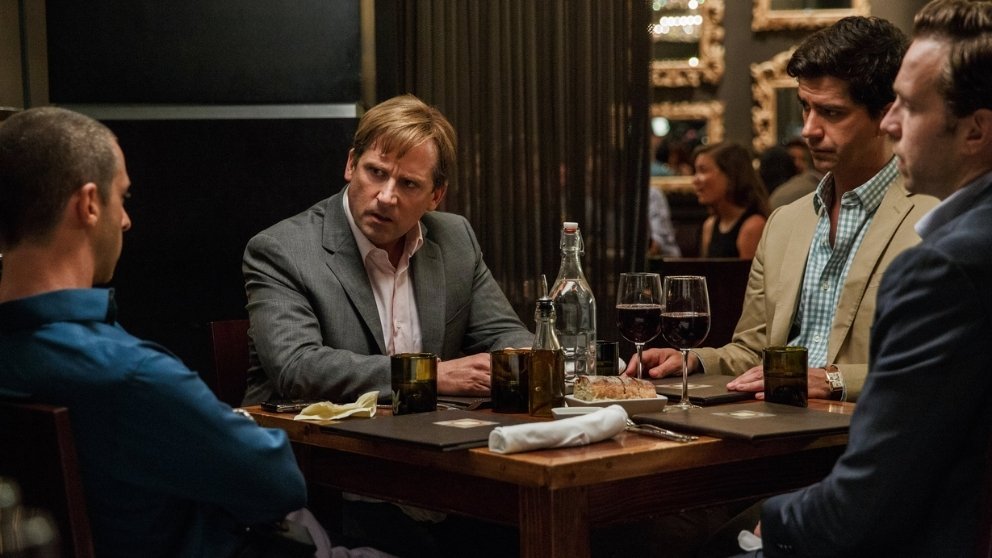 Picture from The Big Short, showing Mark Baum and his team in a tense restaurant meeting, discussing the looming financial crisis.